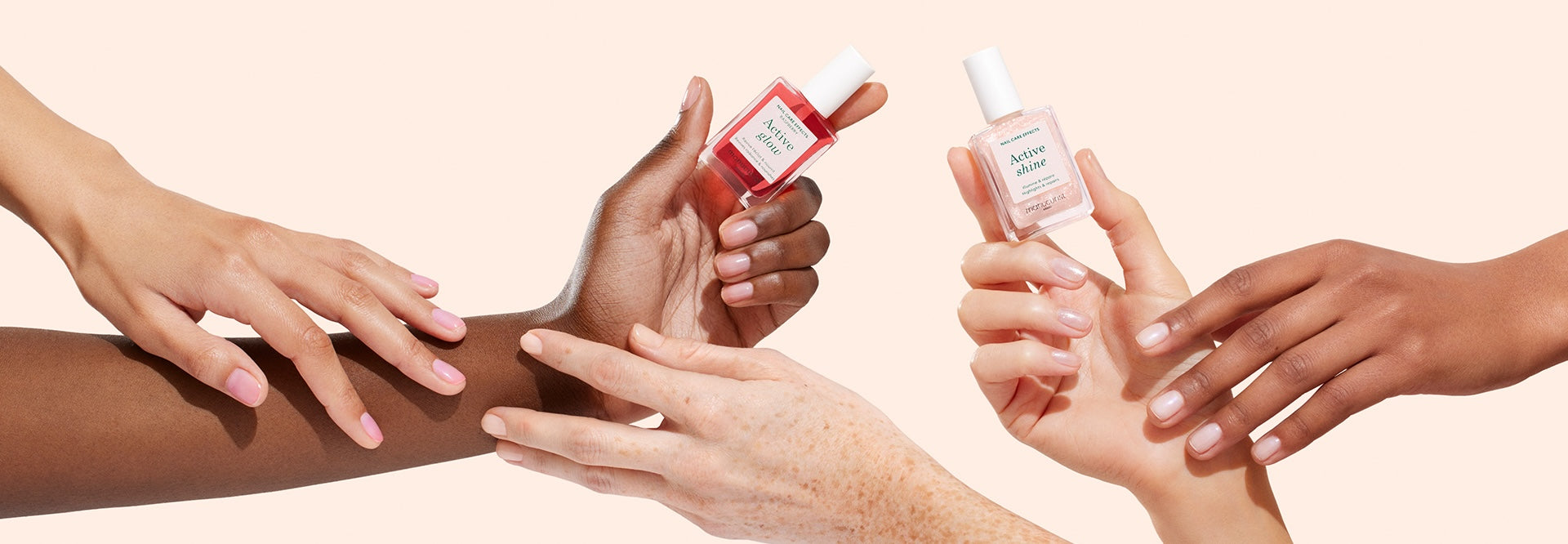 Multiple hands with neatly manicured nails hold and display bottles of nail polish against a light peach background. Two hands hold pink and red nail polish bottles, while others gently touch an arm.