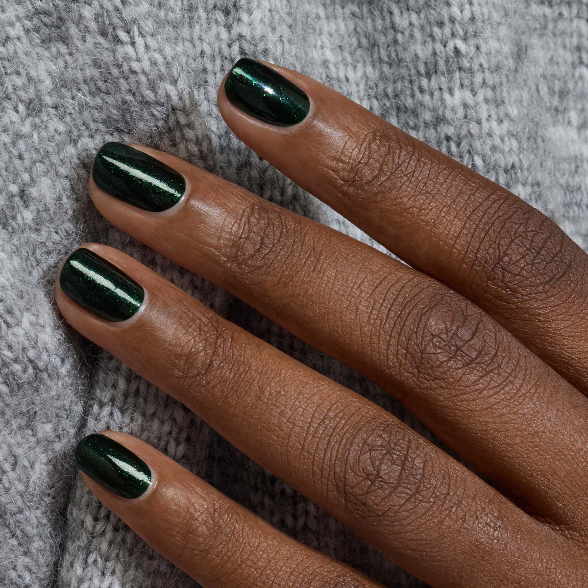 A hand with short, neatly manicured nails painted in Manucurist&