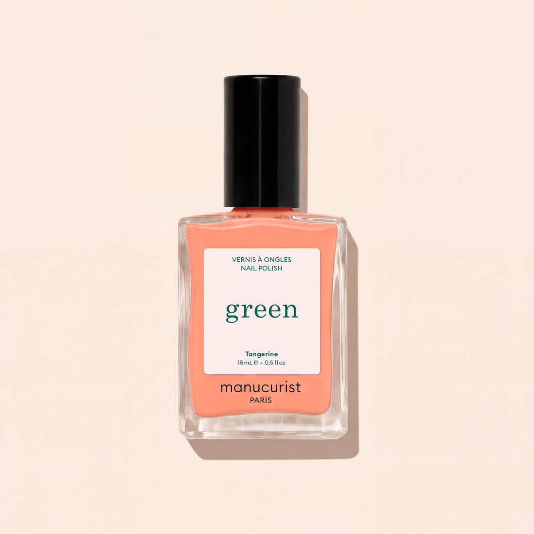 A bottle of Manucurist Tangerine nail polish, a neon light orange shade, features a black cap and minimalist label, displayed on a light beige background.