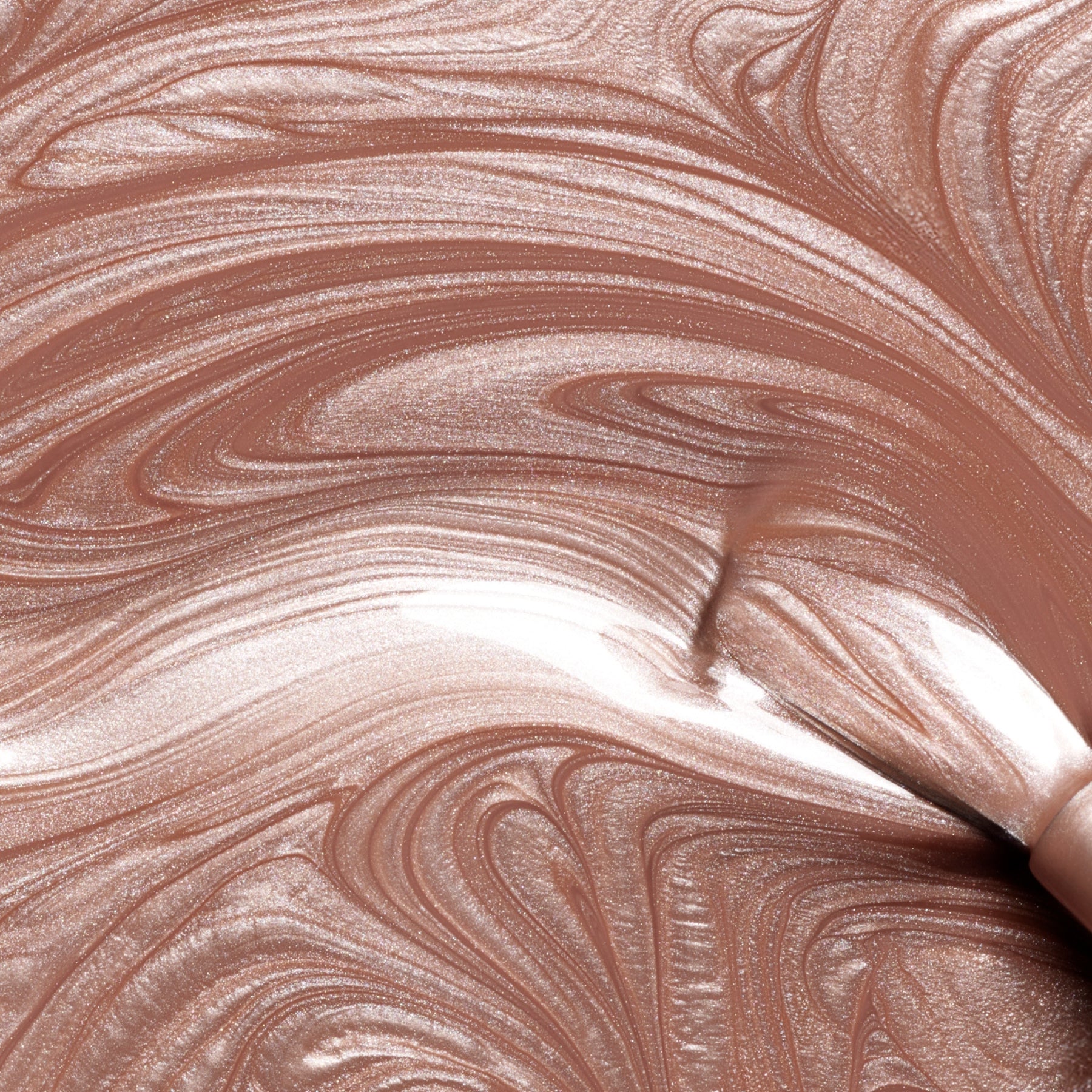 Swirled, shimmery brown and beige liquid paint from Manucurist’s Sandstone—resembling a pearly brown nail polish—creates a marbled pattern with a metallic sheen and smooth texture.