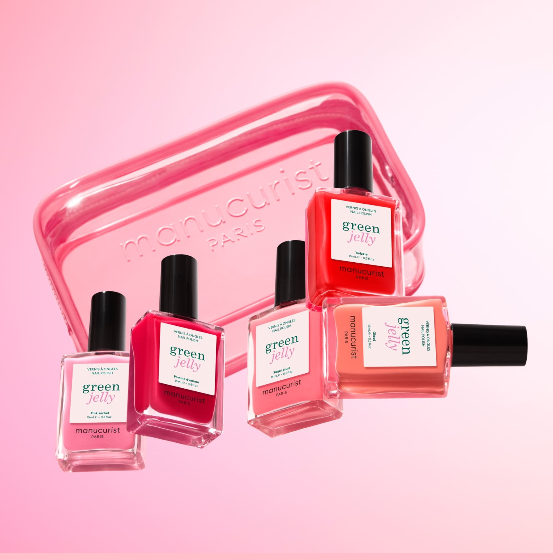Five vibrant nail polish bottles and a translucent pink Mini Jelly Bag by Manucurist are displayed on a pink gradient background, making it a perfect travel manicure set. The bottles include shades green and green jelly.