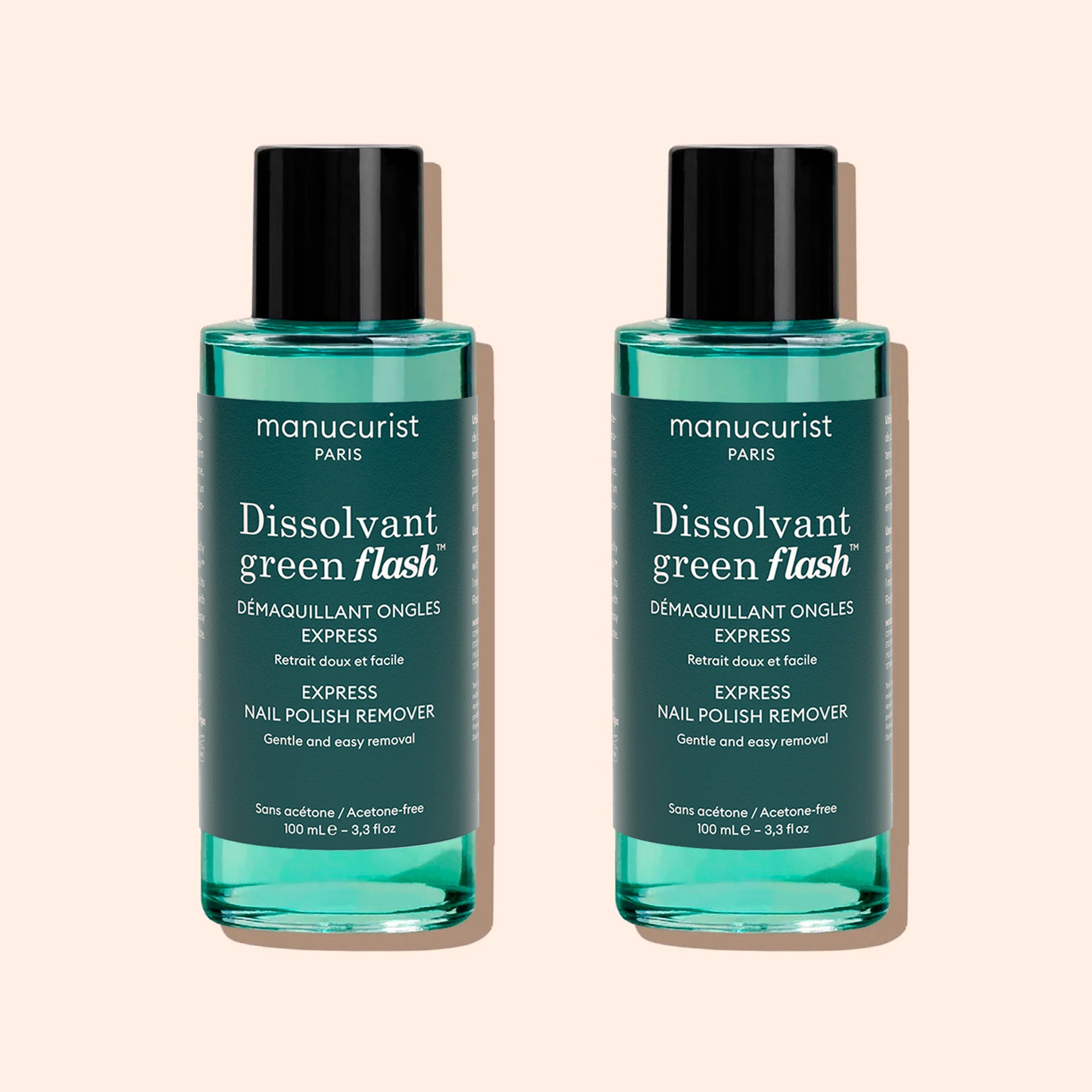 Two bottles of Manucurist Green Flash™ Gel Polish Remover, featuring teal liquid, black caps, and white label text, are displayed against a light beige background.