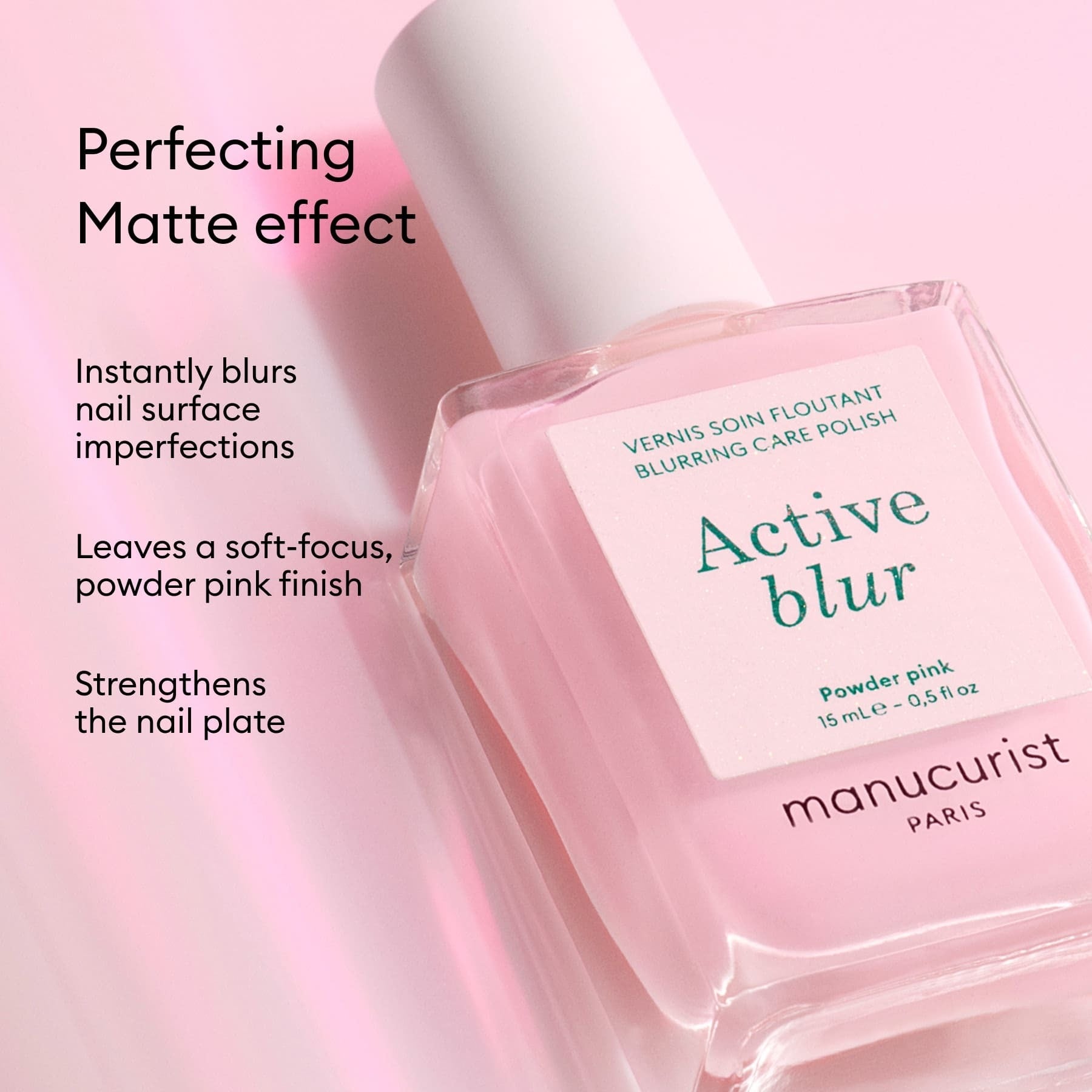 Manucurist Active Blur, a nail-enhancing polish, rests on a pink surface. It offers a perfecting matte finish, instantly blurs imperfections, gives a powder-pink soft-focus effect, and strengthens your nails.