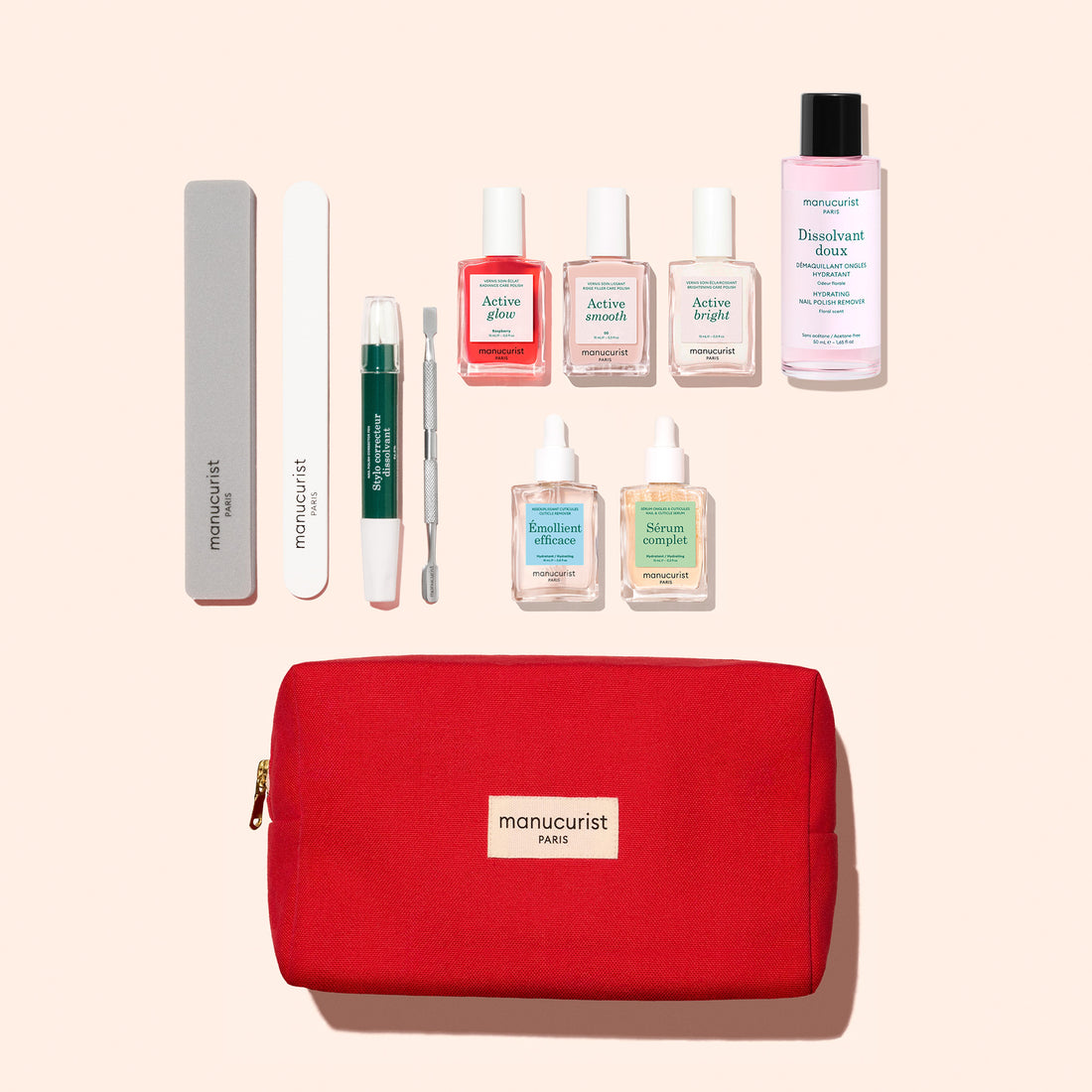 The Manucurist Active™ Ultimate Manicure Kit is displayed in a red pouch and features nail files, cuticle oil, nail polishes, polish remover, a buffer, manicure tool, and treatment bottles for healthy nails—all neatly arranged on a light background.