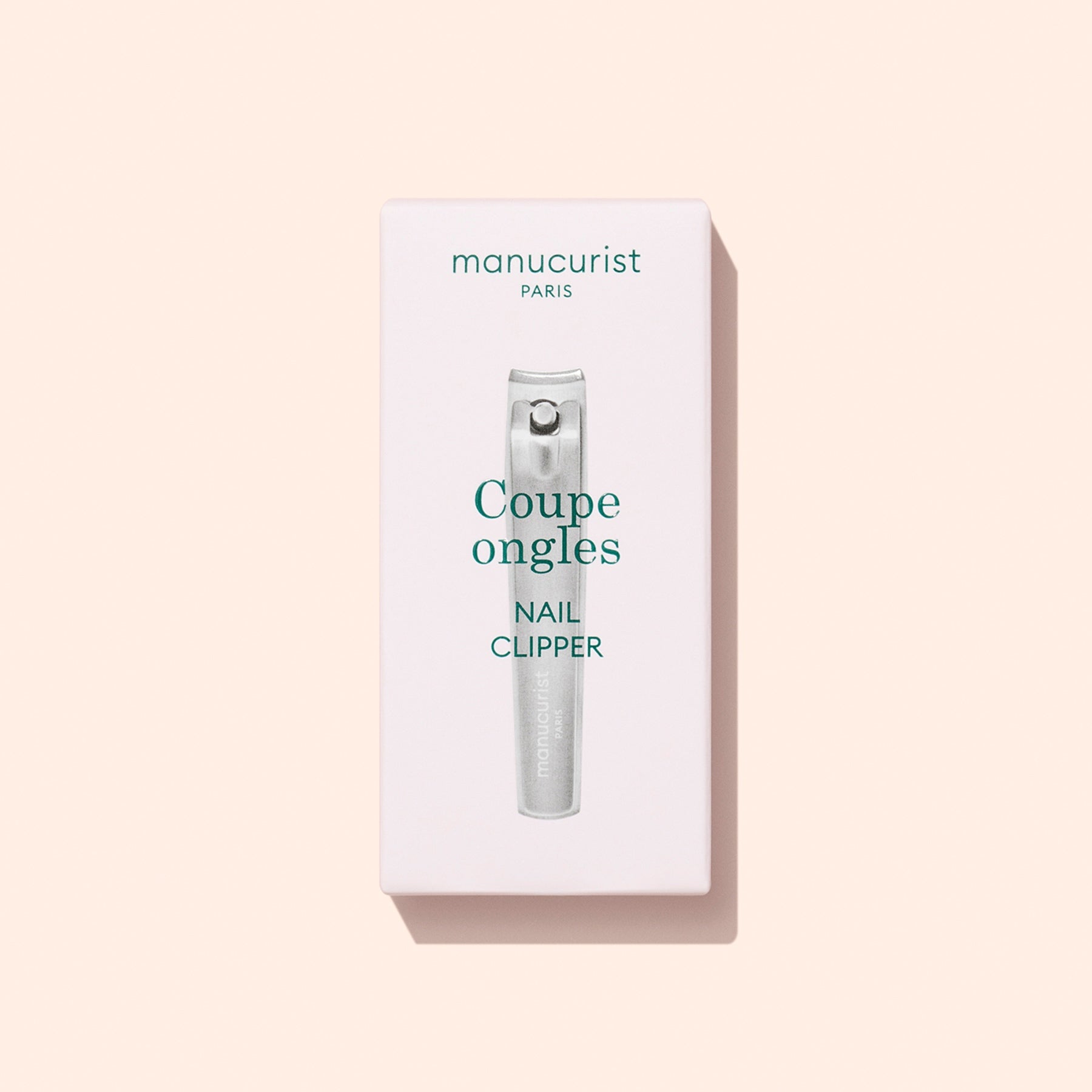 A box of Manucurist Nail Clipper is displayed on a light beige background. The packaging features an image of the nail clipper along with text in French and English, highlighting it as the ideal tool for maintaining natural nails and achieving a flawless manicure.