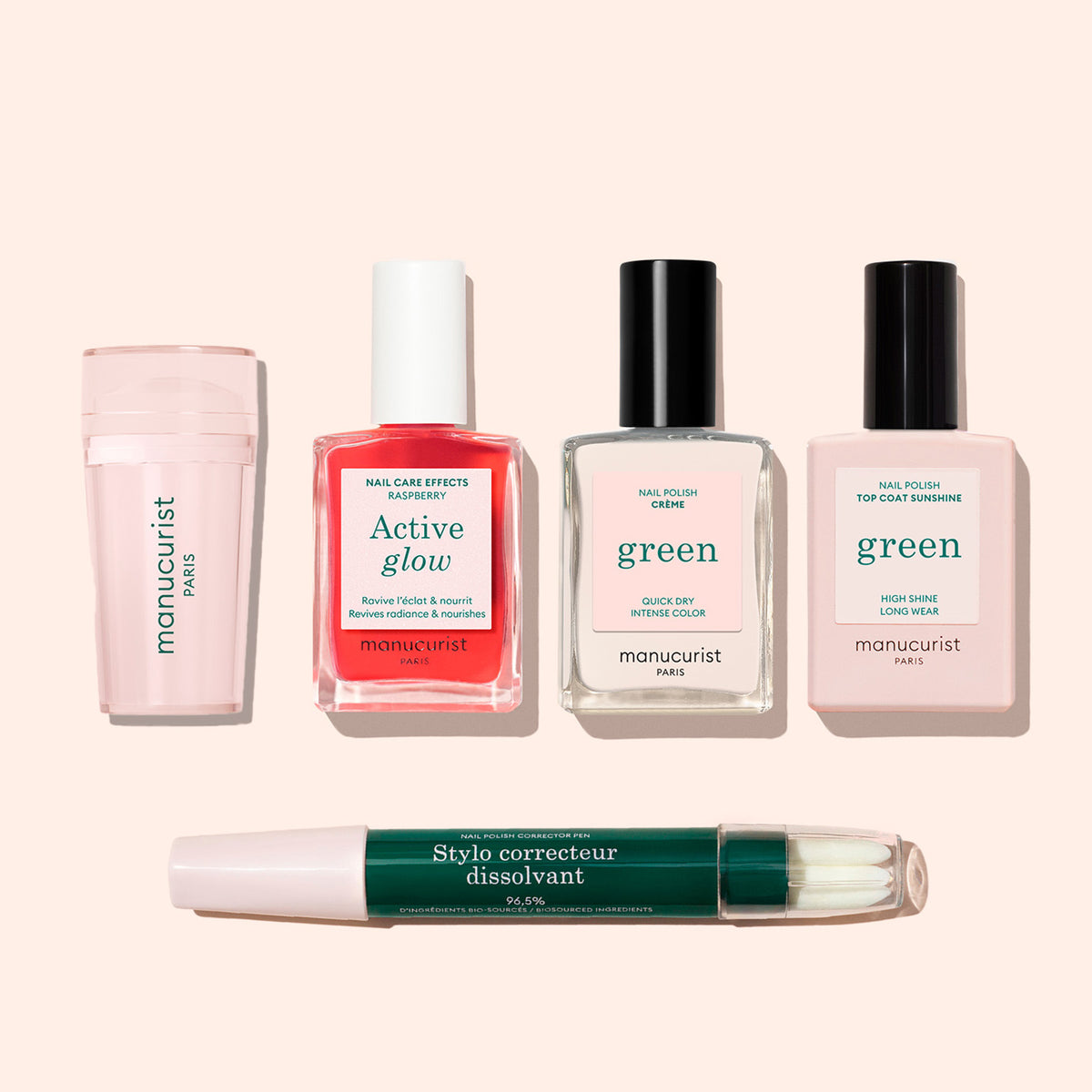 The Manucurist Mani stamper and four other manicure essentials—a pink buffer, red and clear polishes, a top coat, and a green-capped correcting pen—are displayed on a light beige background for perfect French tips.