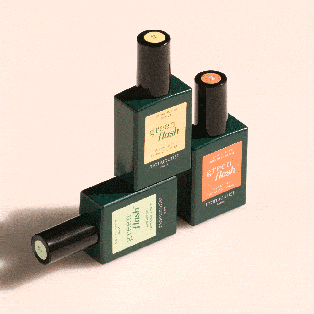 Three rectangular bottles of Manucurist Customisable Trio Green Flash gel polish are stacked in a geometric arrangement on a light beige background, each in green-tinted glass with different colored labels.