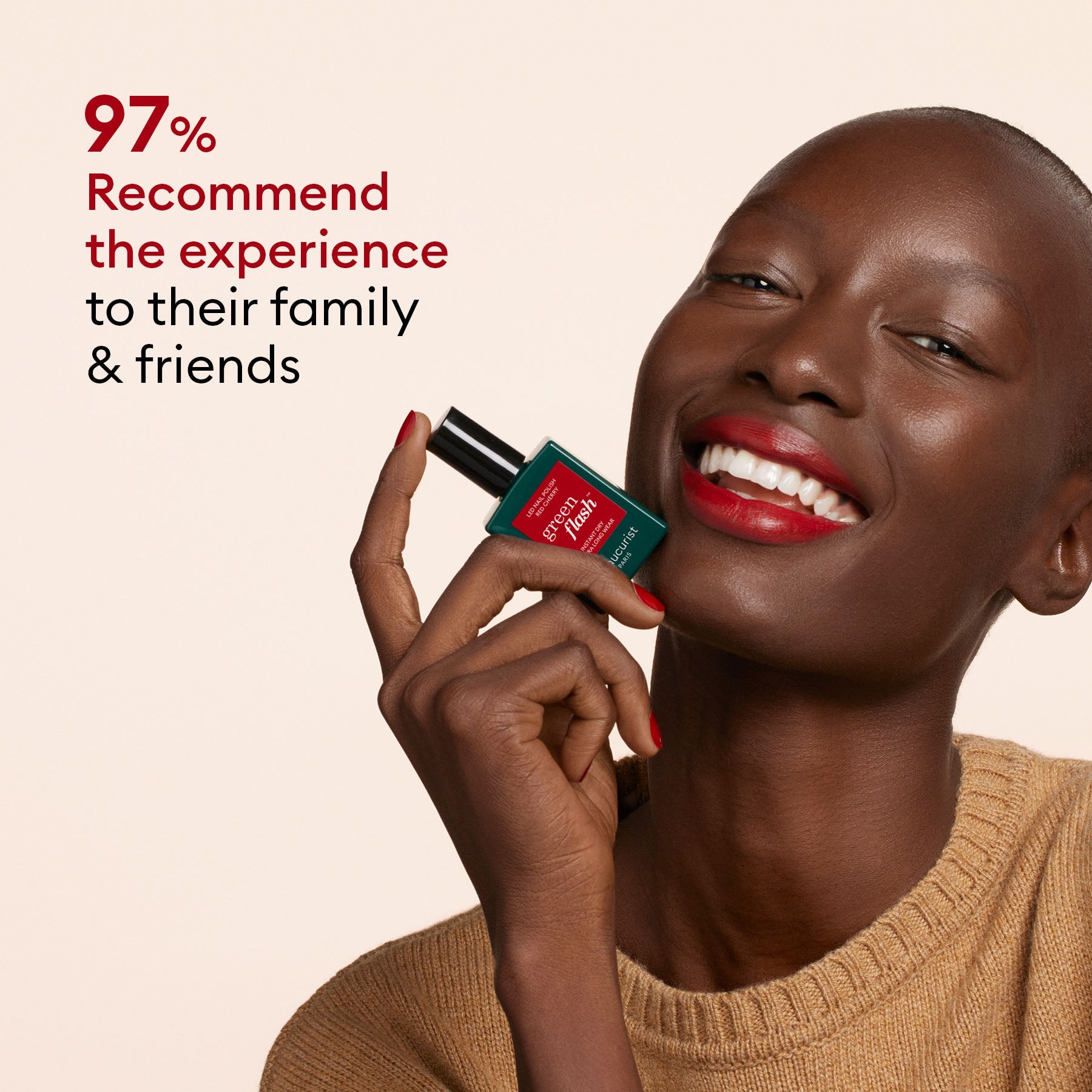 A smiling person with dark skin, red lipstick, a tan sweater, and red-painted nails holds Manucurist’s Welcome Kit Green Flash™. Text beside them reads: 97% recommend the experience to their family friends.