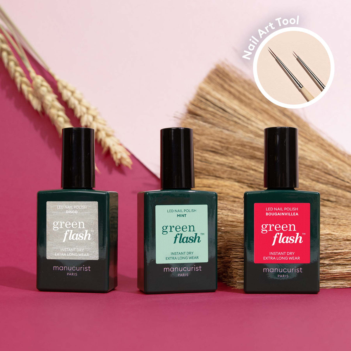 Three bottles from Manucurist’s Coral Reef collection in silver, green, and red sit on a pink surface with dried wheat stalks; a circular inset highlights Nail Art Brush tools, ideal for creating Coral Reef designs.