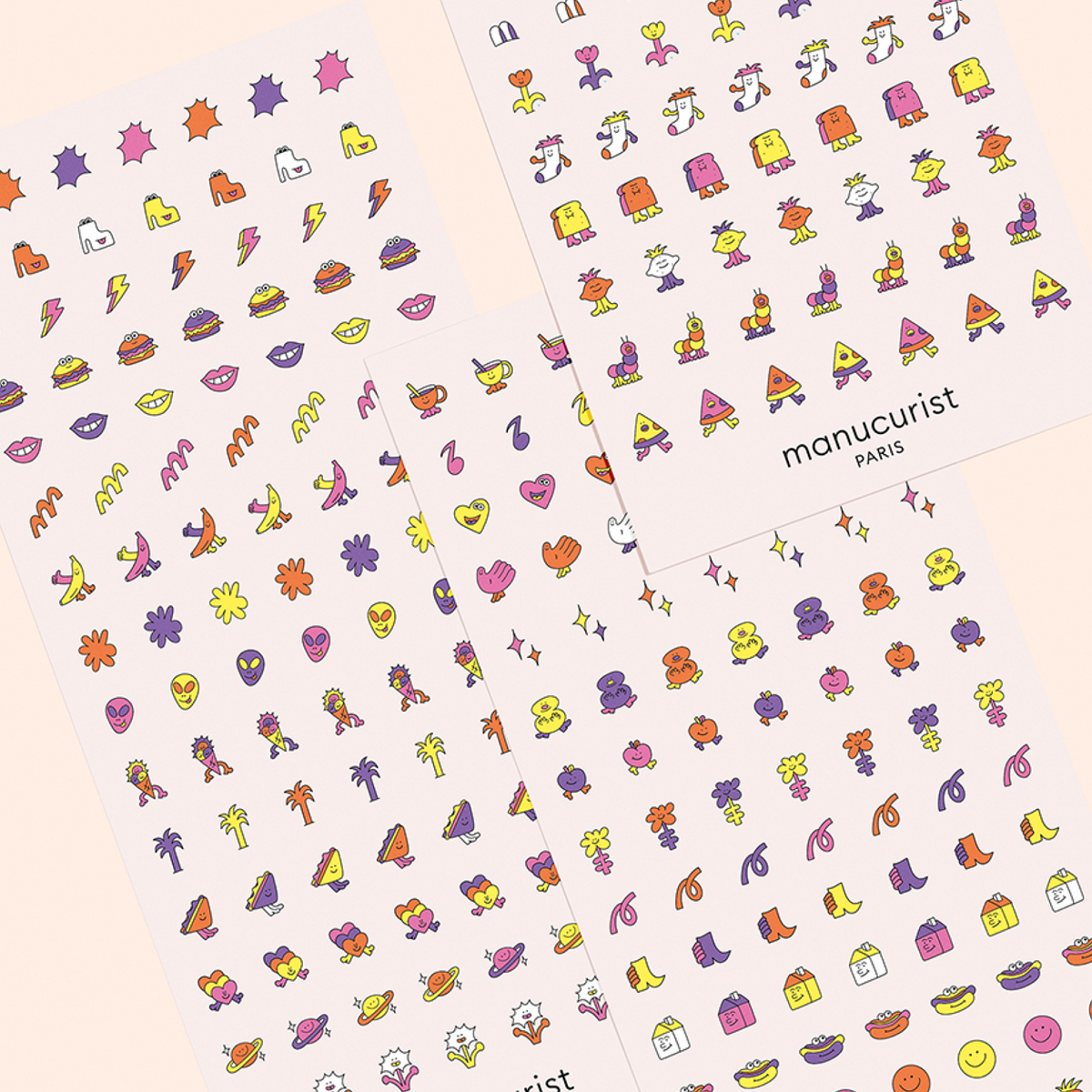 Three sheets of Manucurist Nail Art Stickers with lips, flowers, fruits, hearts, stars, and geometric shapes in purple, orange, and yellow—perfect for creative manicures.