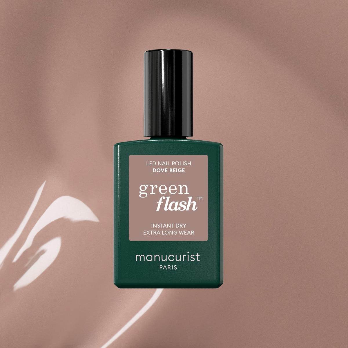 A bottle of Manucurist Dove Beige Green Flash gel polish, in a dark green rectangular bottle with a black cap, is displayed against a soft pastel beige background with glossy highlights.