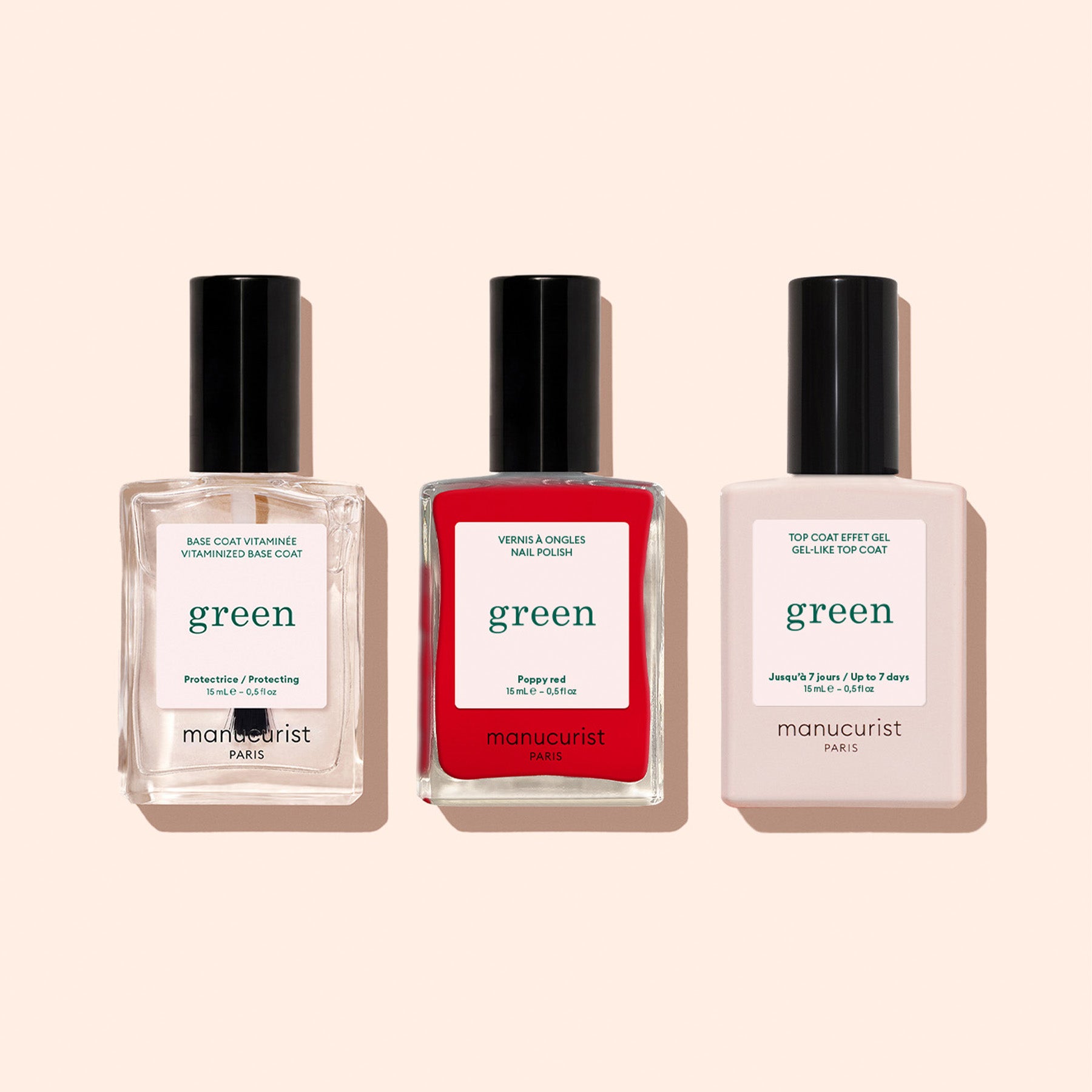 Three bottles from the Manucurist Basic Kit in a row on a beige background: clear base coat, bright red polish, and top coat—all with black caps and white labels for perfect gel-effect manicures.