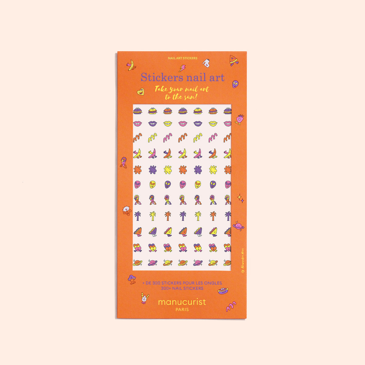 A rectangular orange package labeled Nail Art Stickers by Manucurist displays colorful summer-themed nail stickers with palm trees, hearts, fruit, and shoes for a fun manicure. The brand name Manucurist appears at the bottom.