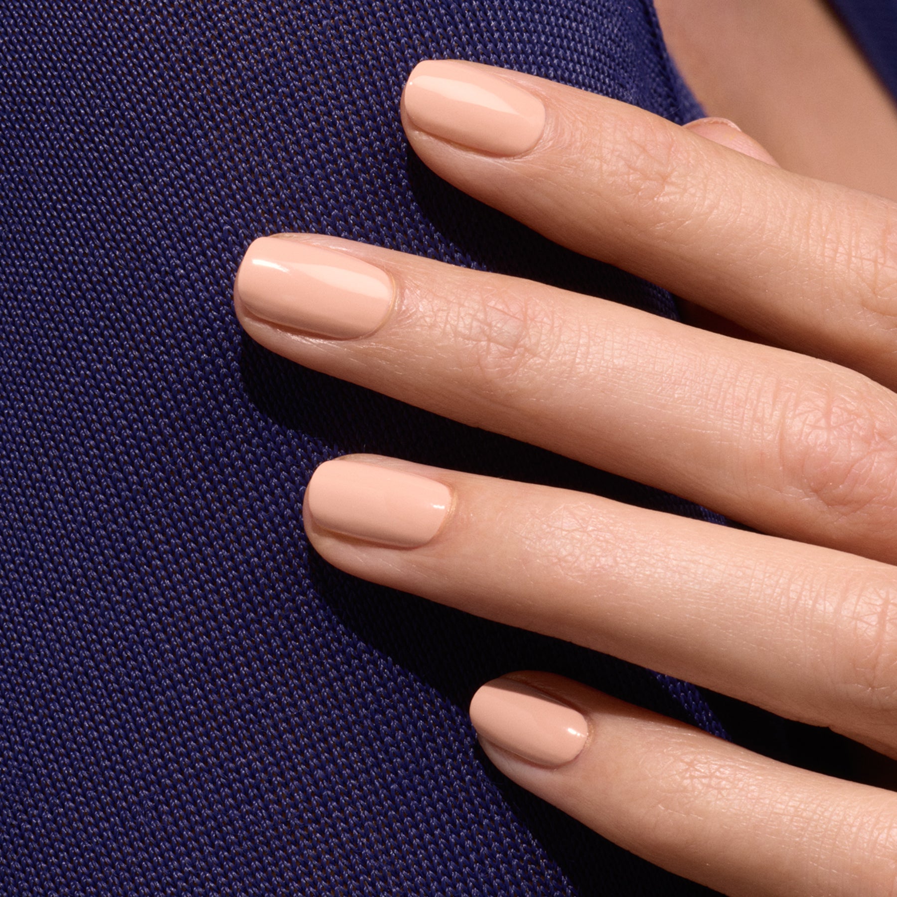 A close-up of a hand with short, neat nails painted in Manucurist&