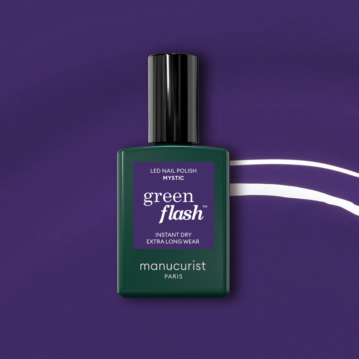A bottle of Manucurist Mystic sits on a purple background with white curved lines. The dark green bottle has a black cap and purple label, ideal for an opaque gel polish finish.