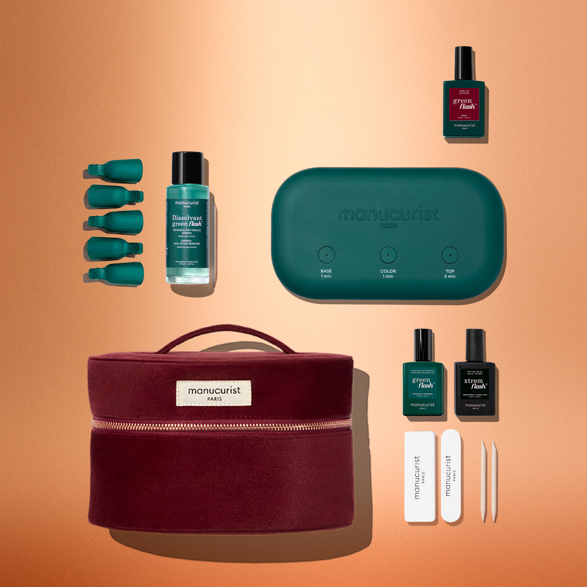 Manucurist Green Flash™ Starter Kit Gift Set including a portable green LED lamp, remover, five finger clips, two polishes, two top coats, two files, and two wooden sticks, all arranged with a zippered burgundy carrying case.