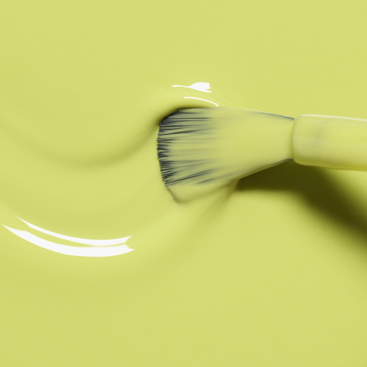 A Manucurist Lime brush glides glossy, vibrant yellow-green polish across nails, leaving gentle ripples and a subtle citrus shine.