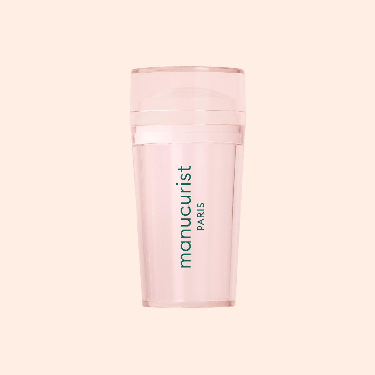 The translucent pink Mani stamper by Manucurist features a cylindrical shape, a lid, and green branding—perfect for flawless French tips. Displayed against a light beige background.