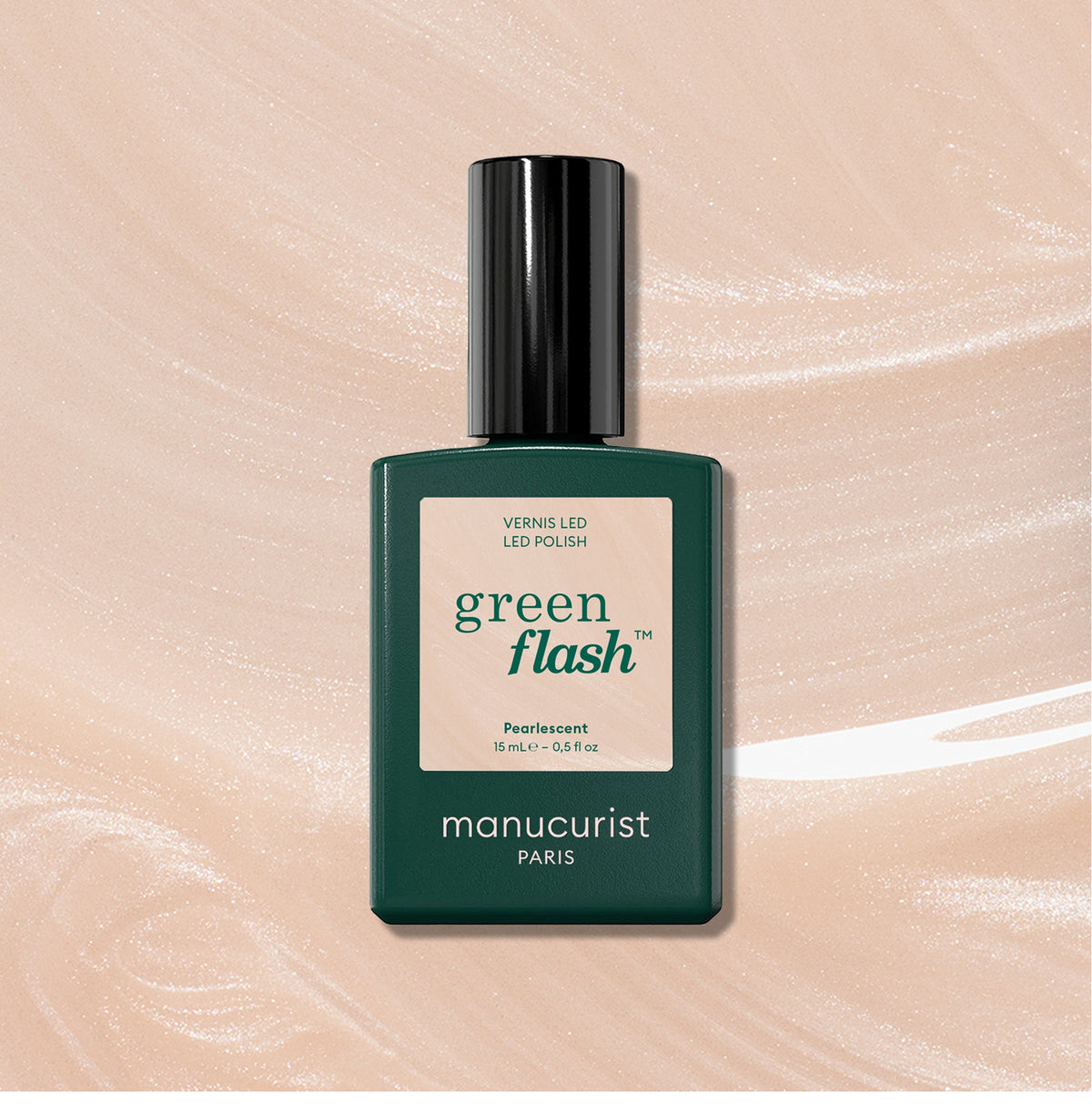 A bottle of Manucurist Pearlescent Green Flash LED Gel Polish with a dark green rectangular body and black cap is shown on a Pearly Beige shimmery background.