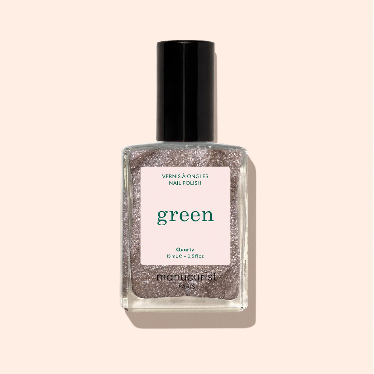 A bottle of Manucurist Quartz nail polish with a black cap and pink label. Quartz is a sparkly brown shade with taupe hints, delivering an intense, glittery finish for eye-catching nails.