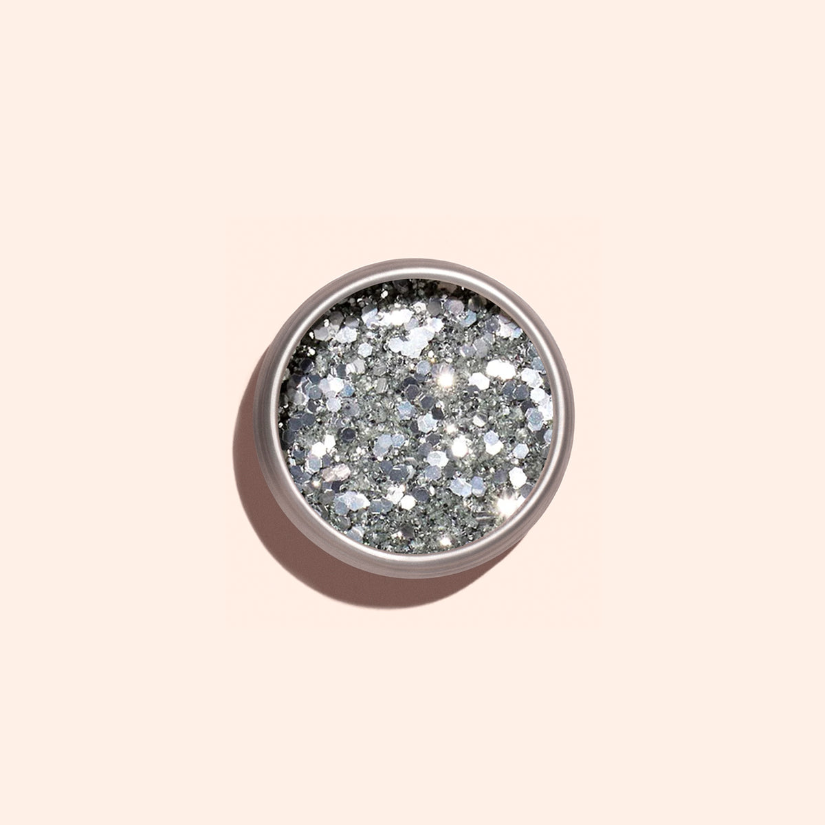 A round container of Manucurist Silver biodegradable glitter, shown from above on a pale beige background—ideal for dazzling nail art designs.