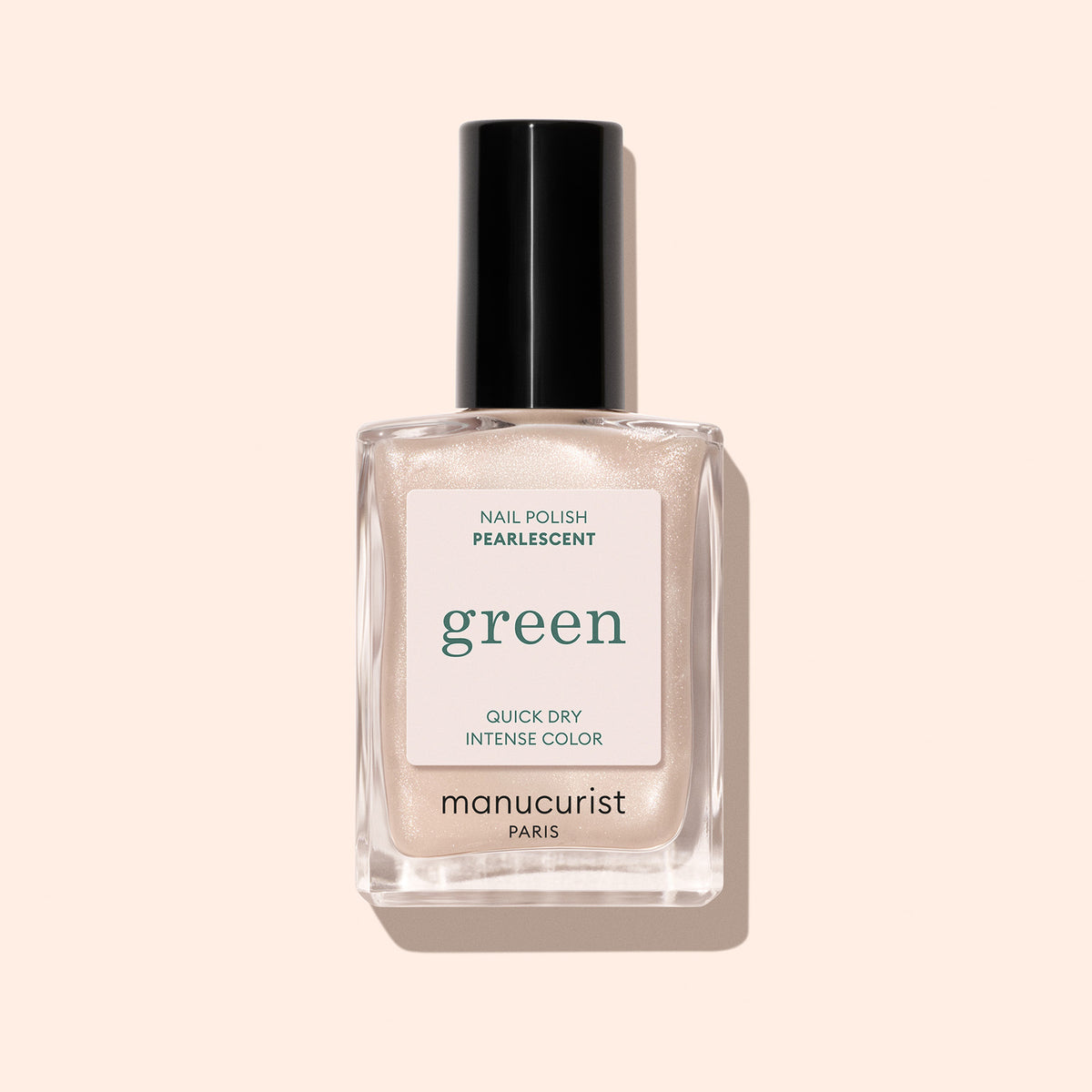 A clear glass bottle of Manucurist Pearlescent nail polish with a black cap. The label features "Pearlescent" and the brand name. The background is solid light beige.