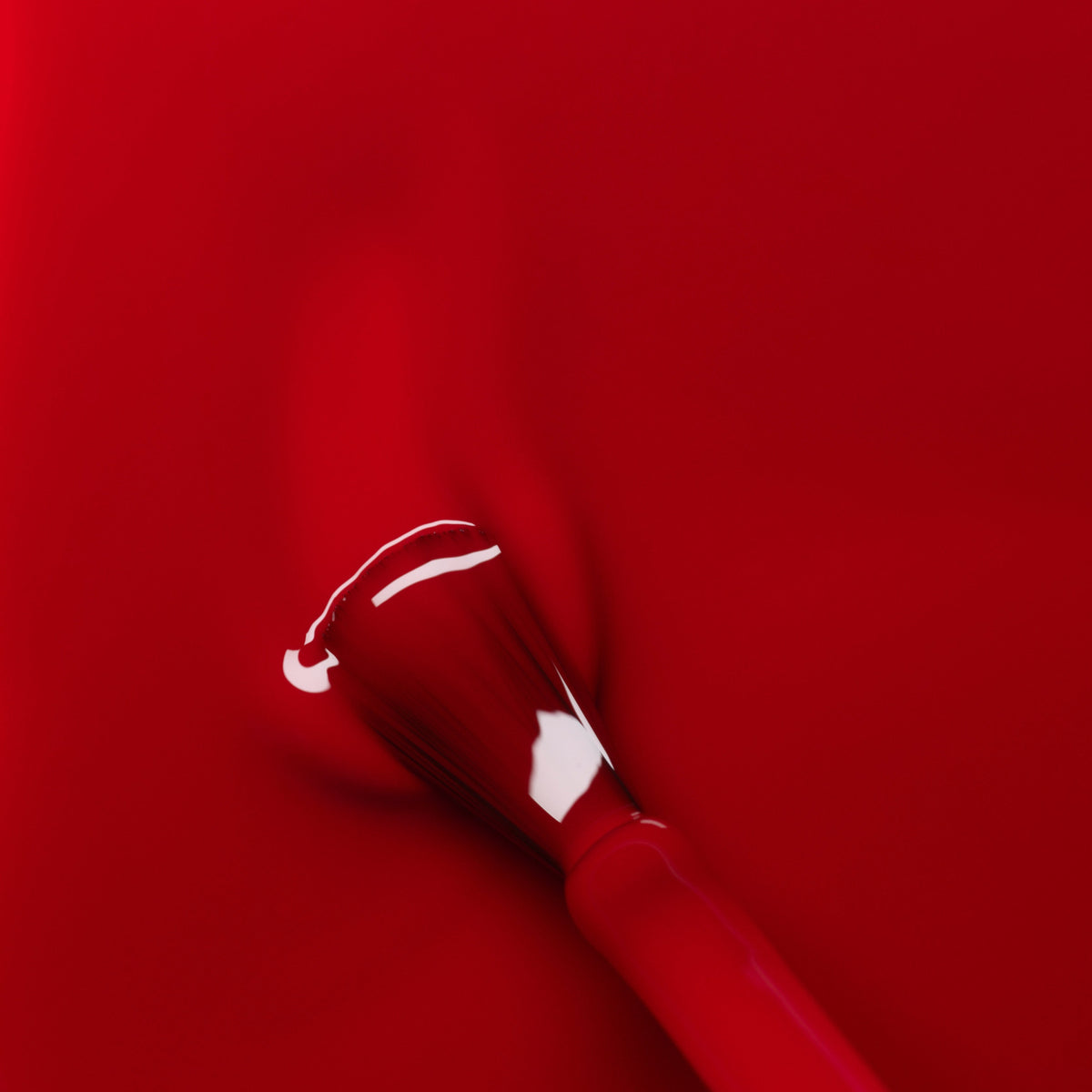 A close-up shows a nail polish brush applying Manucurist’s Red Cherry, delivering smooth, even coverage and a glossy shine from the Green™ range.