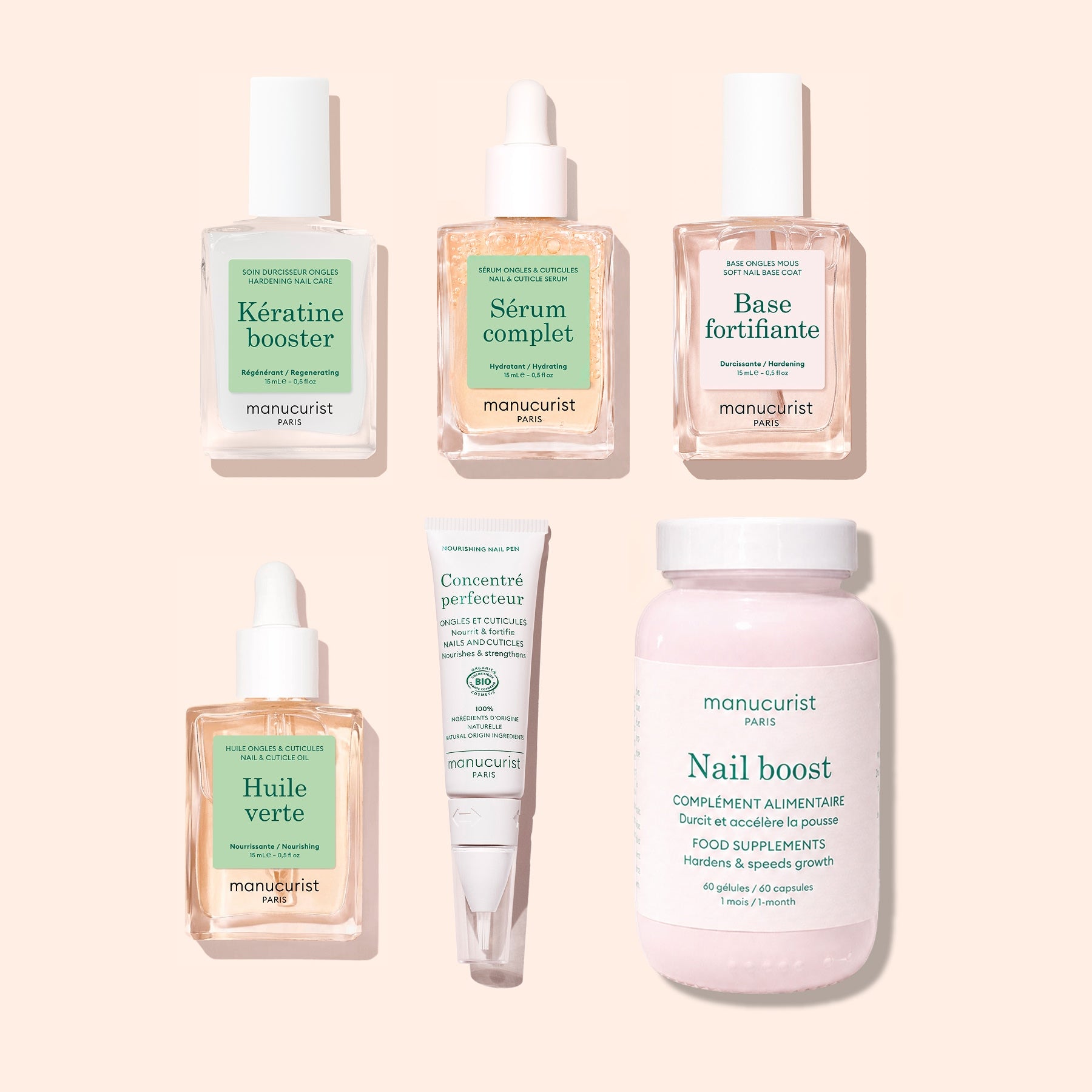 Six manicure essentials from Manucurist’s Basic Routine – Soft Nails set—including bottles and a jar—are neatly arranged on a pale pink background. The labels feature items like Keratine Booster, Nail Strengthening Serum, Sérum Complet, Base Fortifiante, and Nail Boost Supplements: perfect for strengthening soft nails and enhancing your nail care routine.