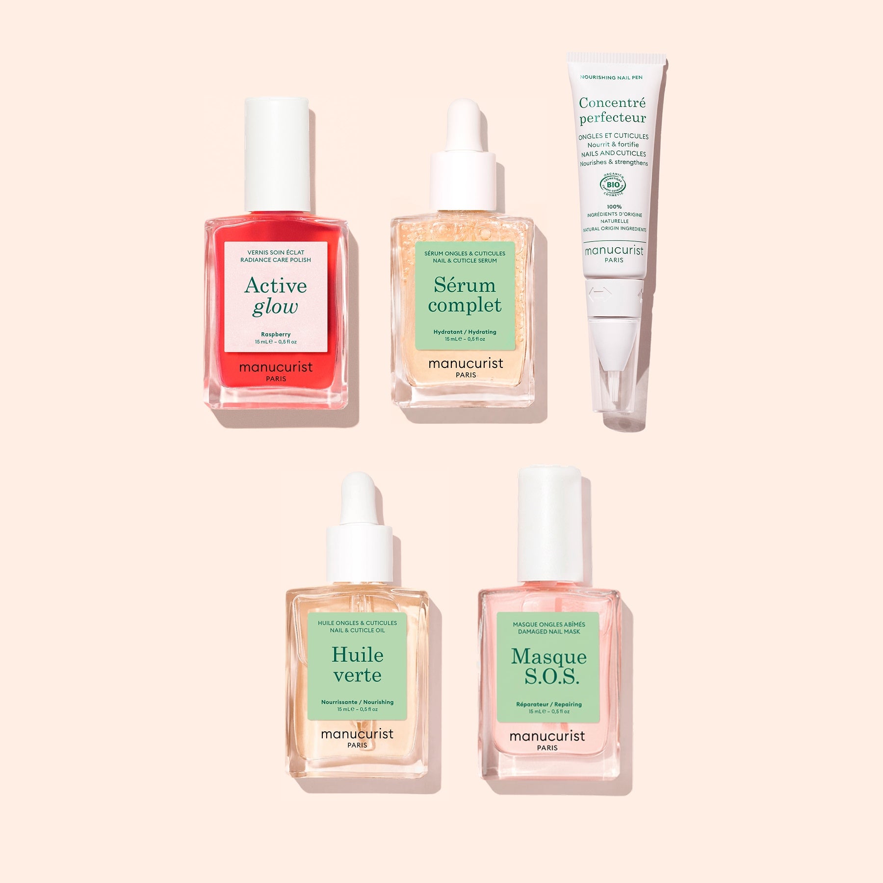 Five Manucurist "Ultimate Routine - Sensitive Nails" products, including four square glass dropper bottles filled with colored liquids and one white tube, are arranged on a light beige background. Created to nourish nails and deliver an effective nail treatment, the pastel-colored labels feature French text.