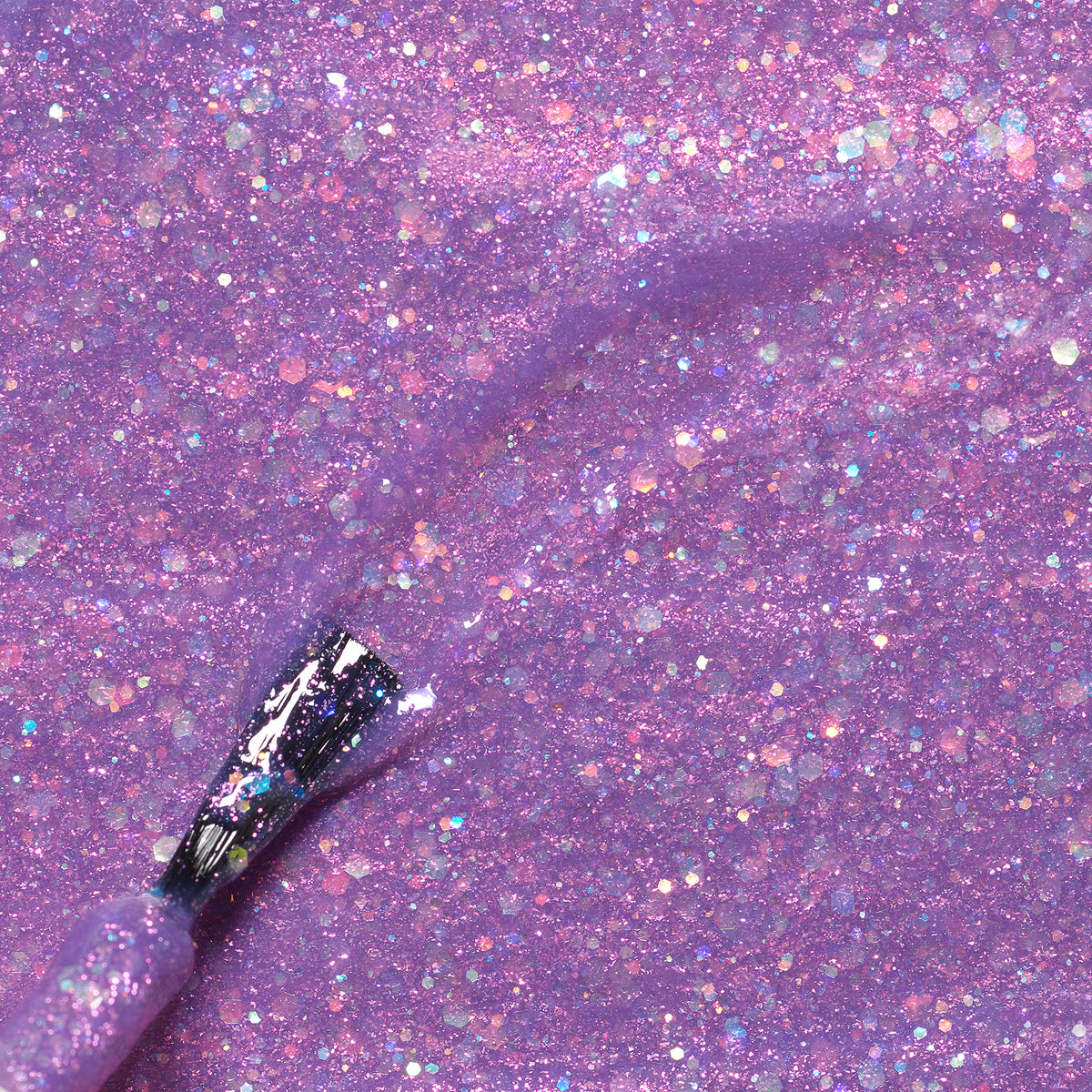 A close-up of the Manucurist Scarlett the Owl brush applying shimmery, glittery purple kids nail polish with natural ingredients onto a matching sparkling purple surface.