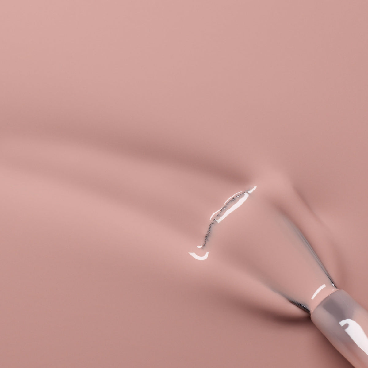 A close-up of a Manucurist Shell Beige nail polish brush applying soft pinkish beige color, leaving a glossy, wet streak on a smooth surface.