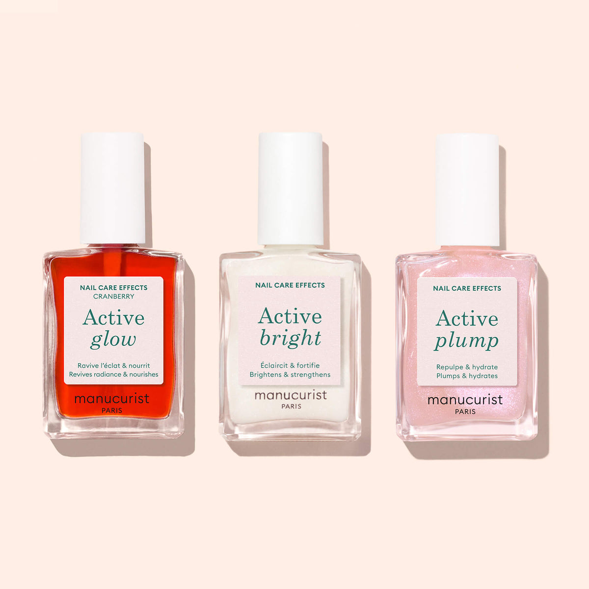 Three manicure bottles labeled Active™ Glow Cranberry, Active Bright, and Active Plump by Manucurist are displayed side by side on a light background. Each bottle features a unique color—red, white, and pink—and boasts a plant-based formula designed to elevate your nail care routine.