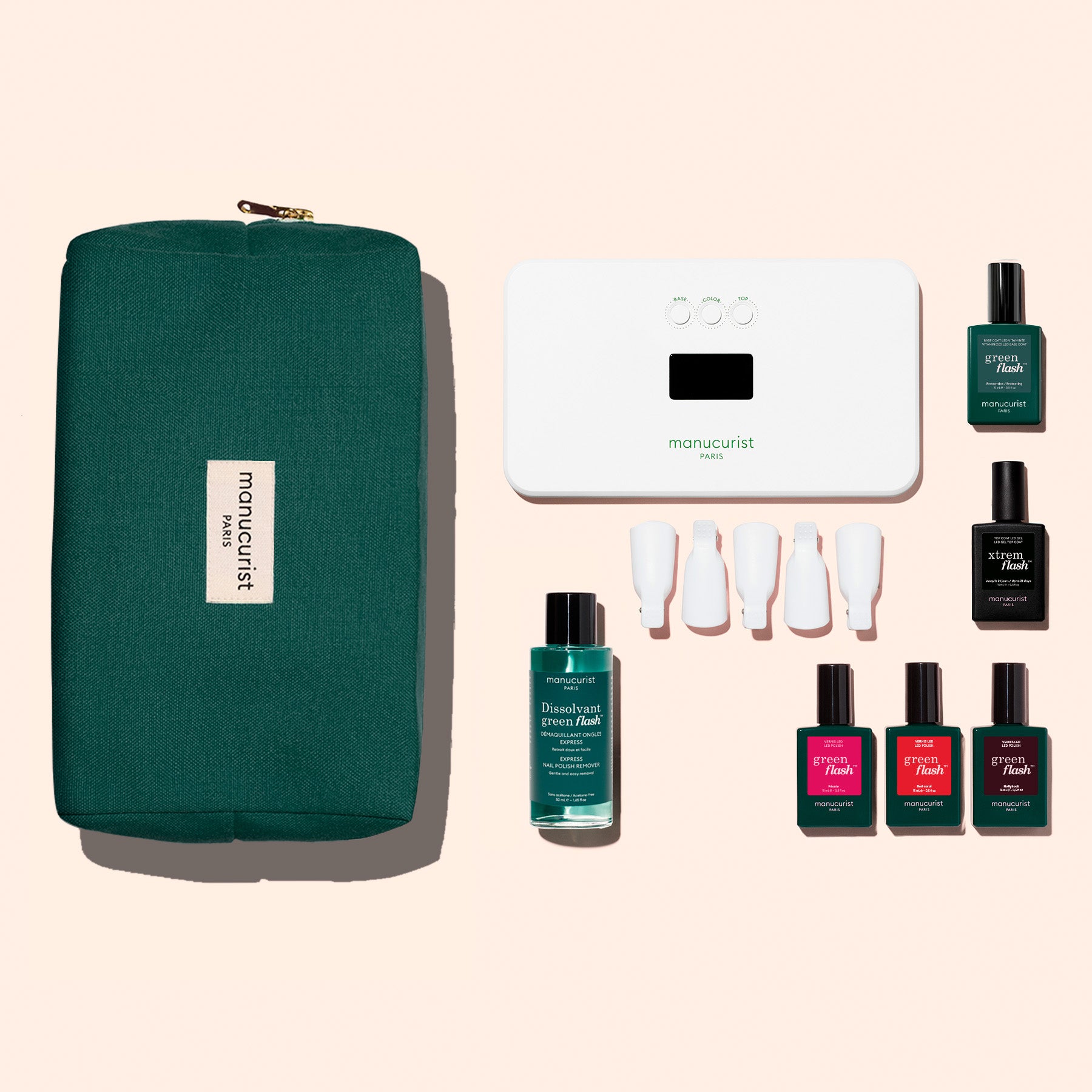 The Manucurist Starter Kit features a green pouch, white LED nail lamp, remover, four caps, and five Green Flash gel polishes for an ultra-glossy manicure—all set against a beige background.