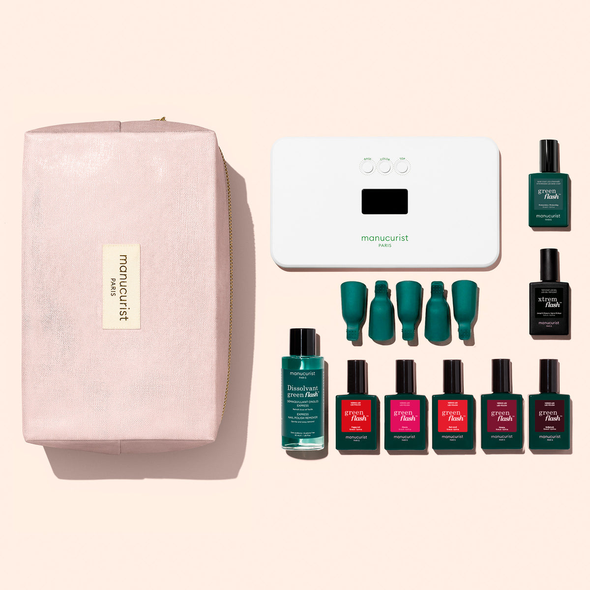 The Manucurist Super Starter Kit is arranged neatly on a light pink background, featuring a pink pouch, white LED nail lamp, green nail polish remover, and eight bottles of Green Flash gel polish in green and pink shades. Enjoy up to 21 days’ wear with the included vitaminized base coat for nails that look fresh and vibrant.