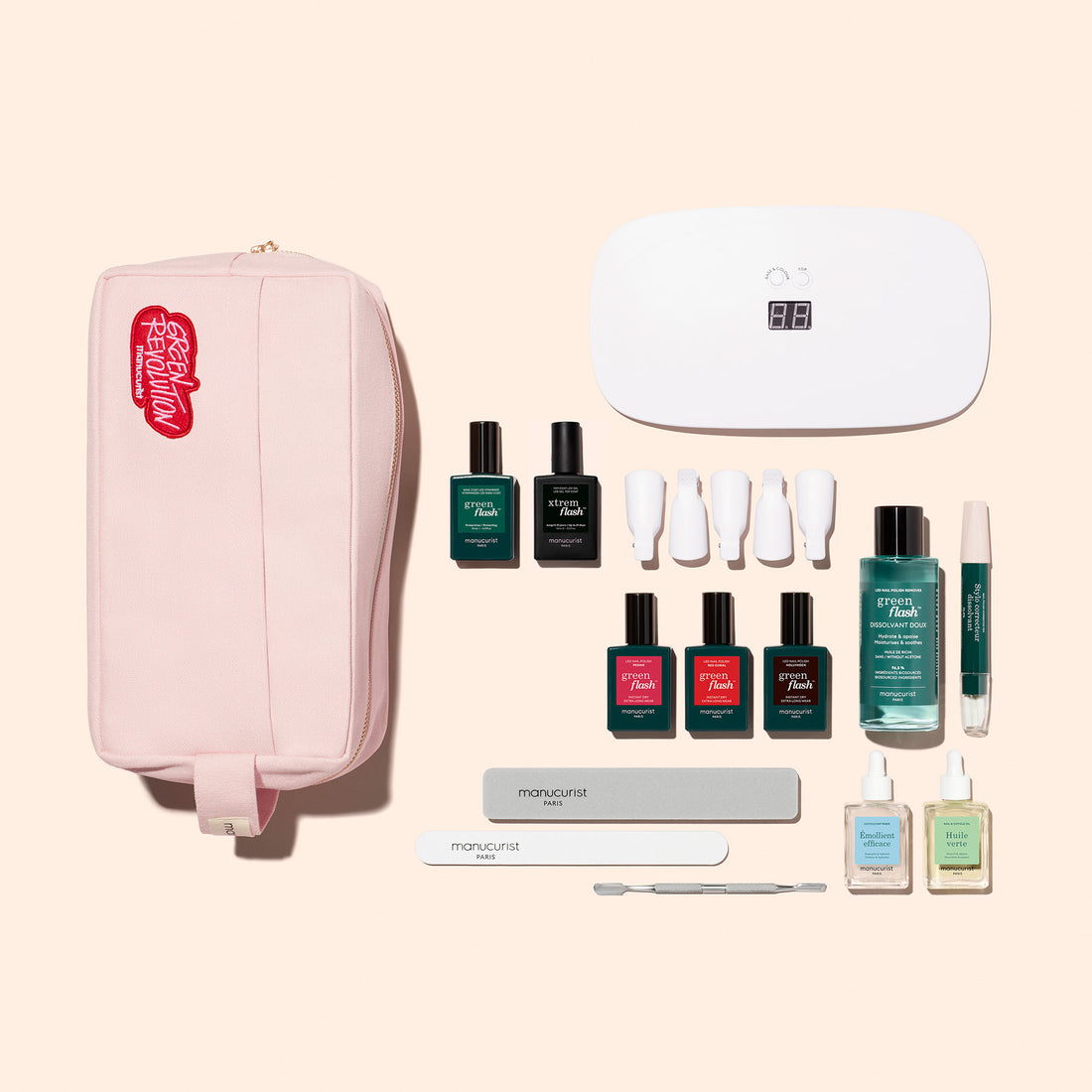 The Manucurist Addict Kit includes a pink zippered pouch, Green Flash gel polish, UV nail lamp, nail files, cuticle pusher, and manicure essentials—everything you need for an ultra-glossy manicure on a light beige background.