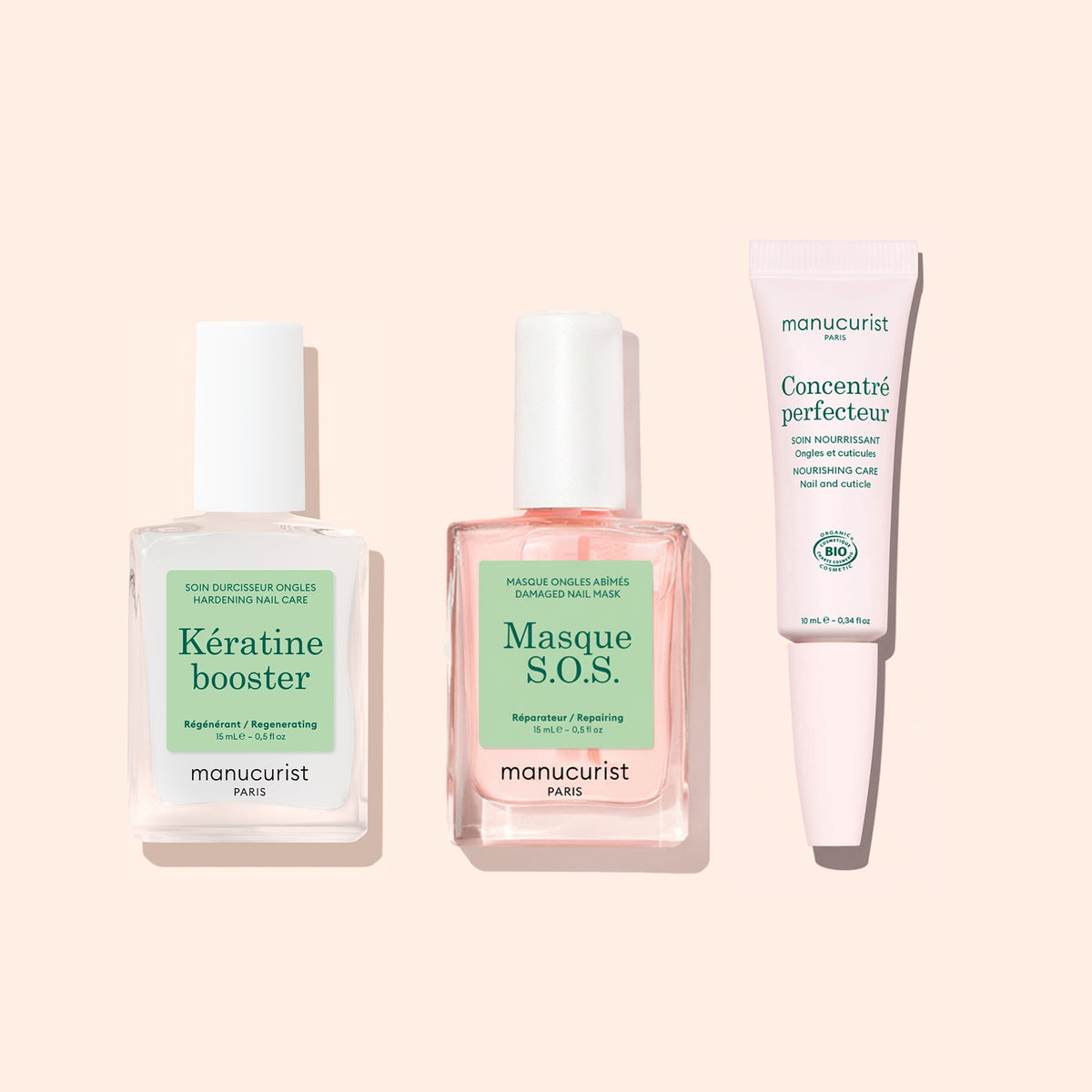 Three nail care products from Manucurist are arranged side by side: Nail Strengthening Serum in a square bottle, Masque S.O.S. overnight mask for damaged nails, and Concenté Perfecteur in a tube.