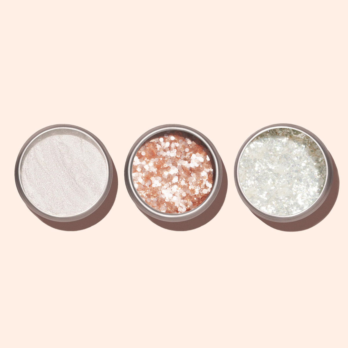 Three open Nacres Flakes containers by Manucurist display shimmery powders and glitters—white, pink with white specks, and silver pearlescent flakes—side by side on a pale background for sparkling manicures.