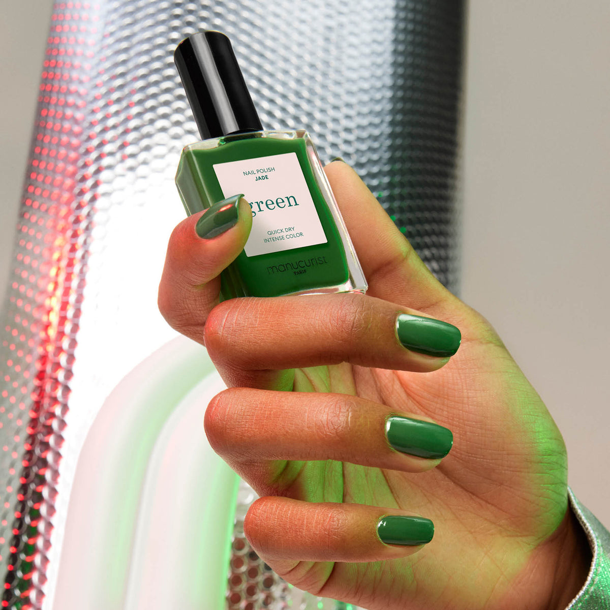 A hand with neatly manicured nails painted in Manucurist&