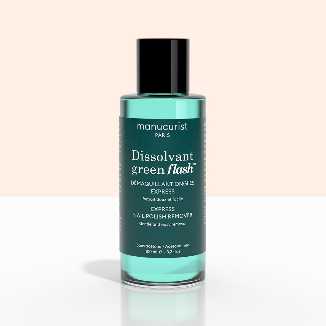 A bottle of Manucurist Green Flash™ Gel Polish Remover, featuring a black cap and green liquid, with a label highlighting its moisturizing, soothing formula ideal for removing gel polish.
