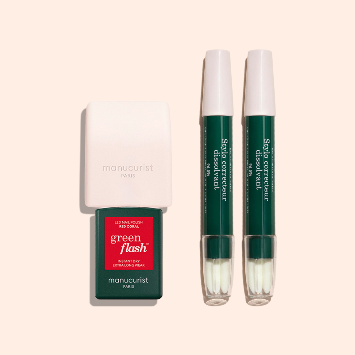 The Mani Helper by Manucurist includes a small LED nail lamp, Green Flash LED nail polish in Red Coral, and two green polish corrector pens, all arranged on a beige background for a flawless manicure and easy application.