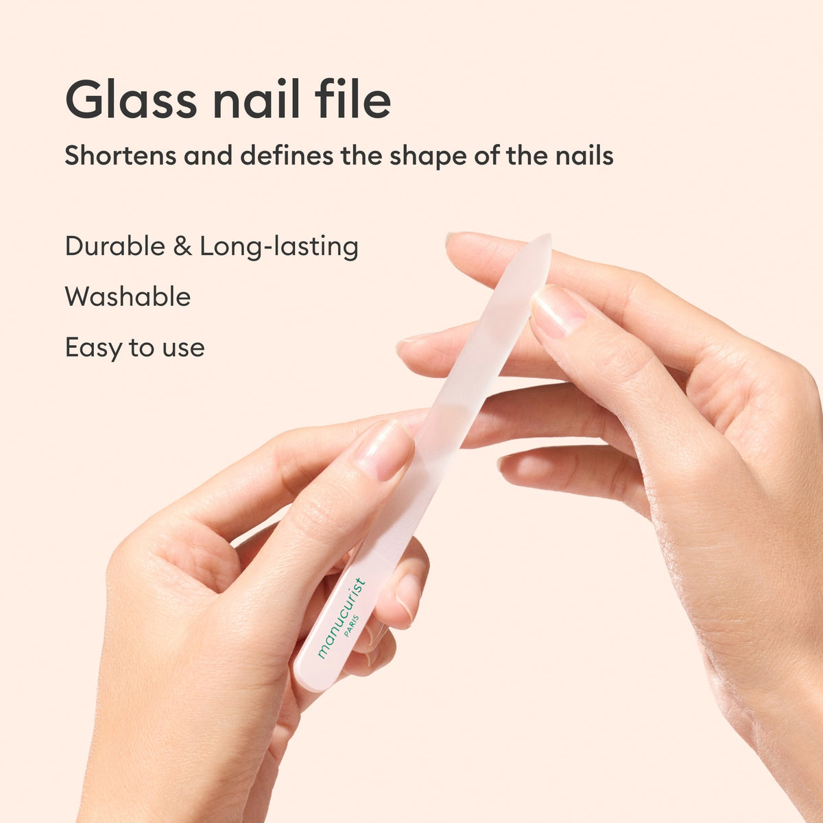 Two hands hold the Manucurist Glass Nail File. Text highlights its durable, long-lasting, and washable design—easy to use and ideal for shortening and shaping nails.