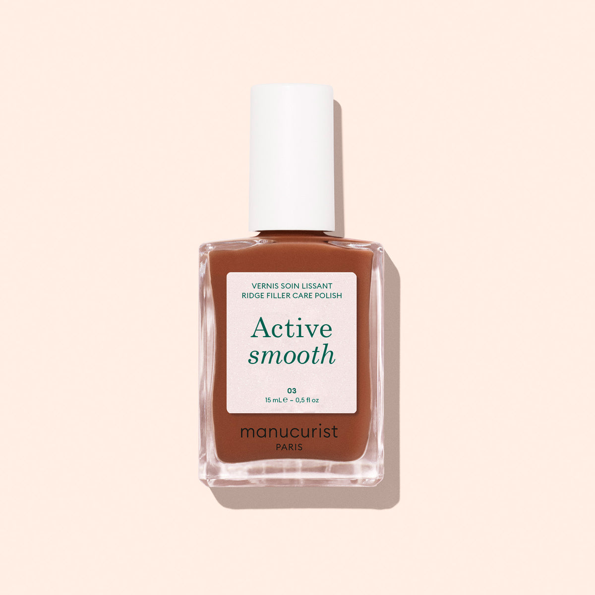 A bottle of Manucurist Active™ Smooth 03 nail treatment, featuring brown liquid, a white label, and a white cap, is photographed against a light beige background with a soft shadow—perfect for elevating your nail care routine. This CC Polish Treatment delivers a subtle Bronze Satin Finish for effortlessly polished nails.
