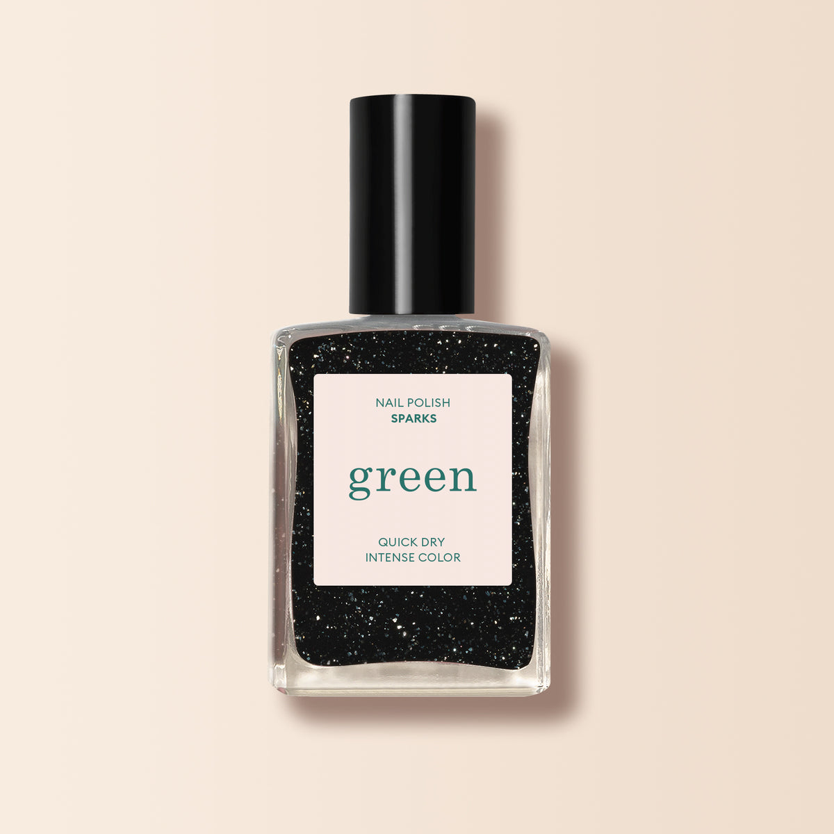A bottle of Manucurist Sparks, a glittery black nail polish with a green label, black cap, and white front label, is set against a light beige background.