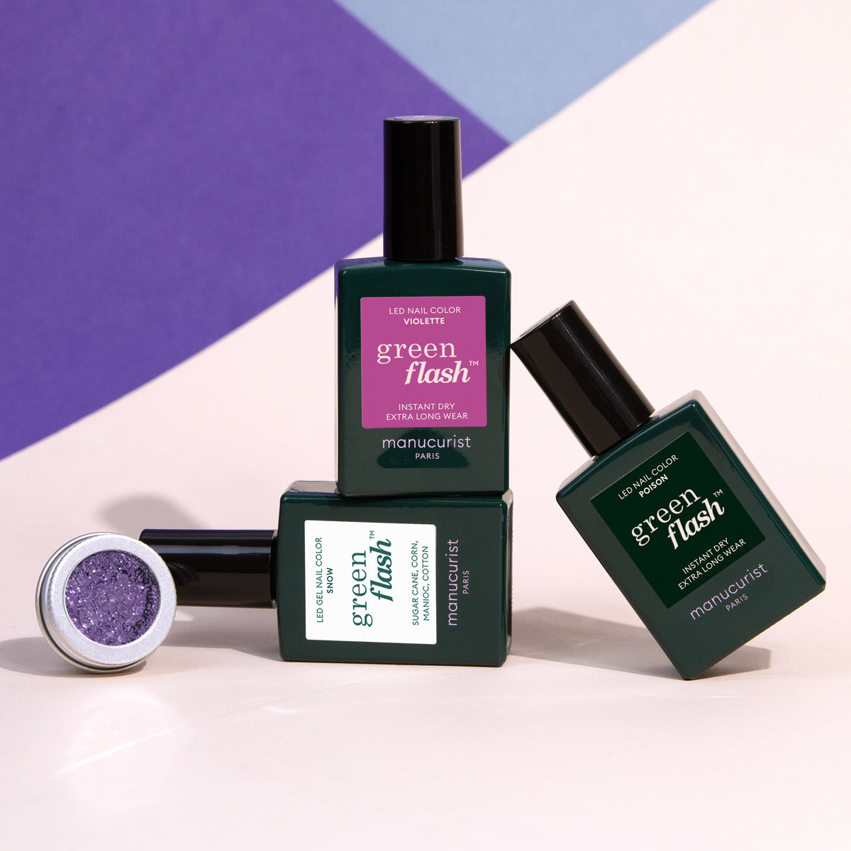 The Manucurist Witchy Wicked Set features three Green Flash LED gel polish bottles in assorted shades, arranged with a tilted bottle and an open pot of biodegradable glitter powder against a partially visible purple background.
