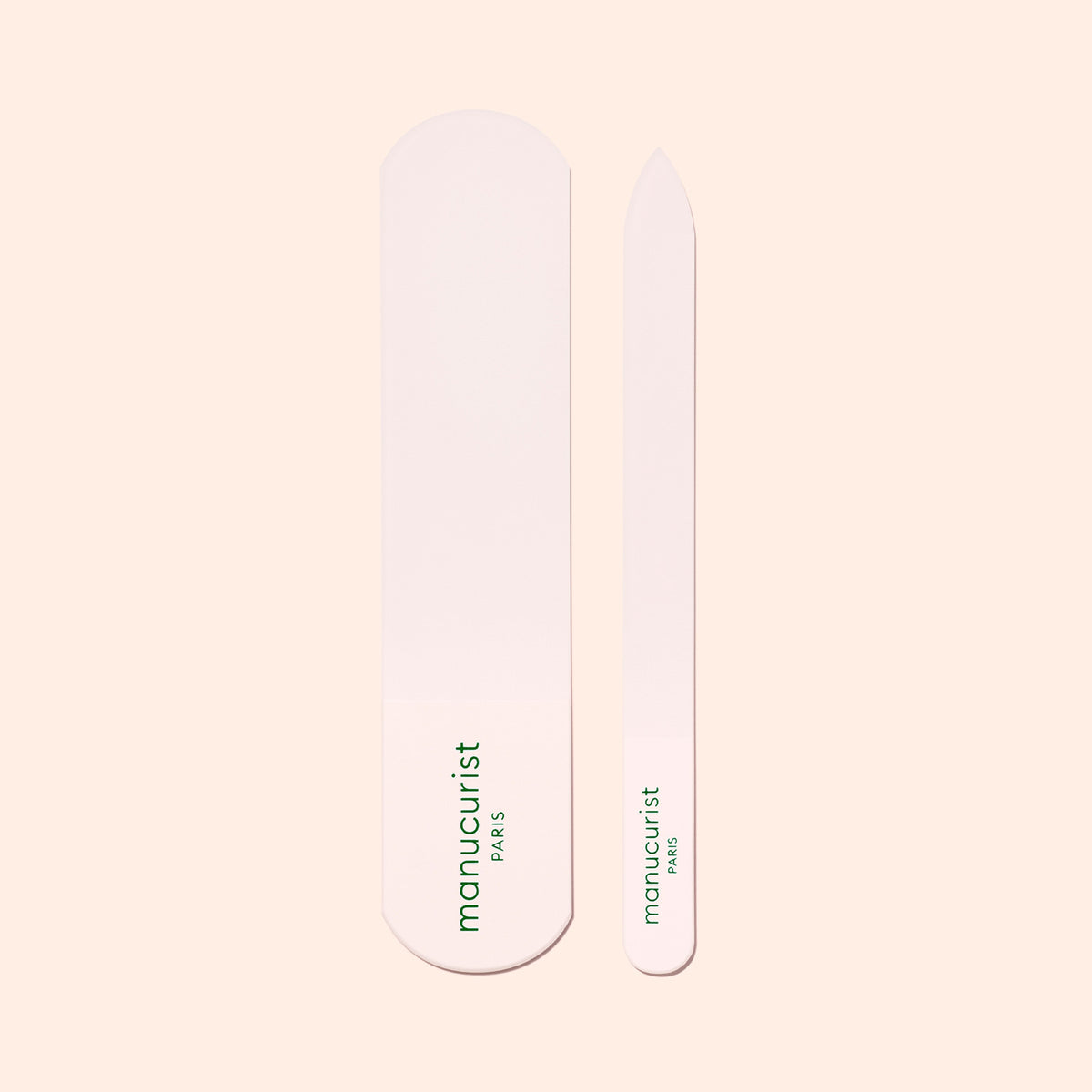 Two light pink nail files of varying sizes sit side by side, each with "manucurist PARIS" in green—perfect for smooth skin when paired with the Manucurist Glass Foot File.
