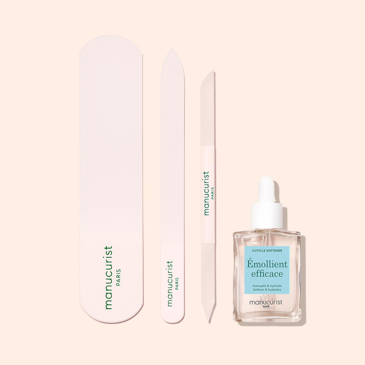 The Manucurist Glass Foot File is displayed vertically alongside a dropper bottle labeled Émollient efficace, ideal for achieving soft, smooth skin on hands and feet.