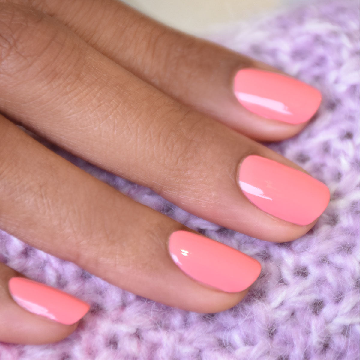A close-up of a hand with neatly manicured nails painted in Pink Paradise polish from Manucurist&