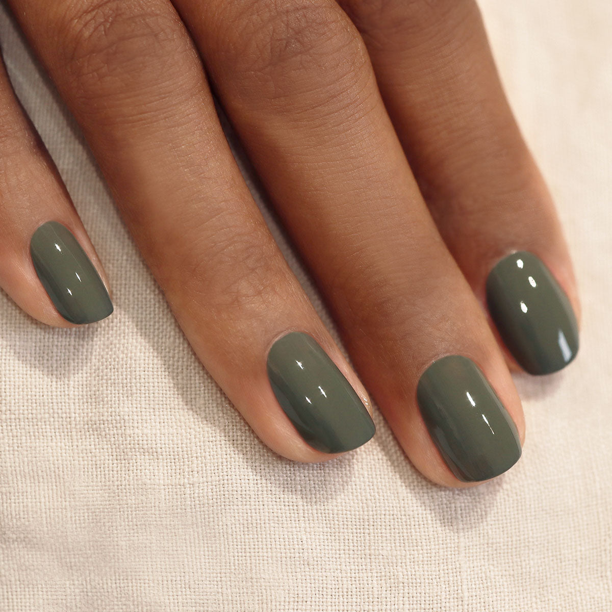 A close-up of a hand with short, neatly manicured nails painted in Manucurist&