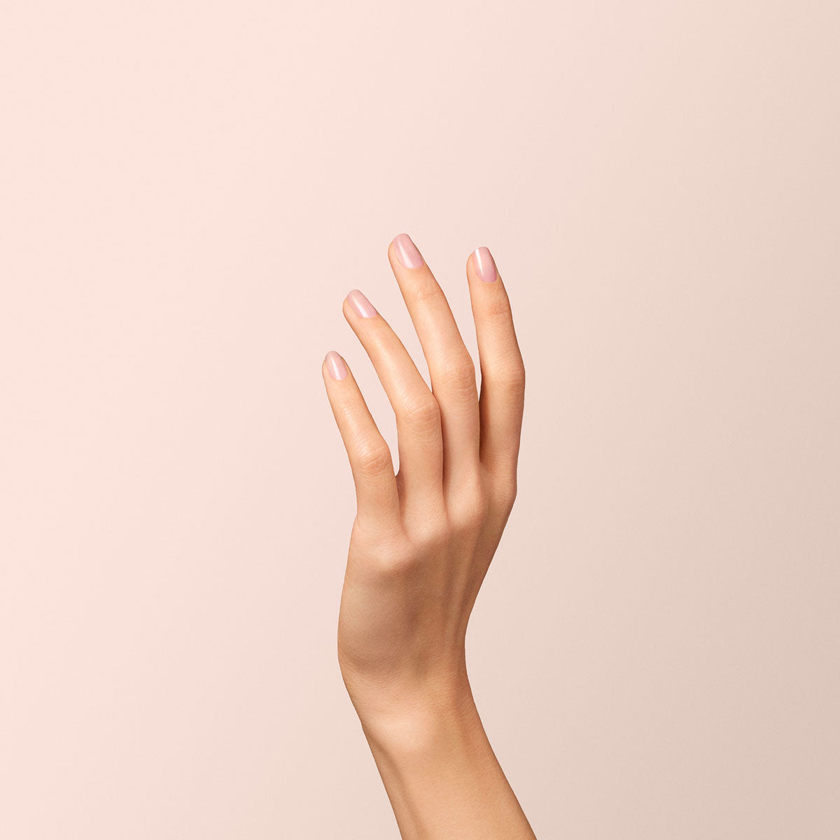 A hand with neatly manicured nails painted in Manucurist&