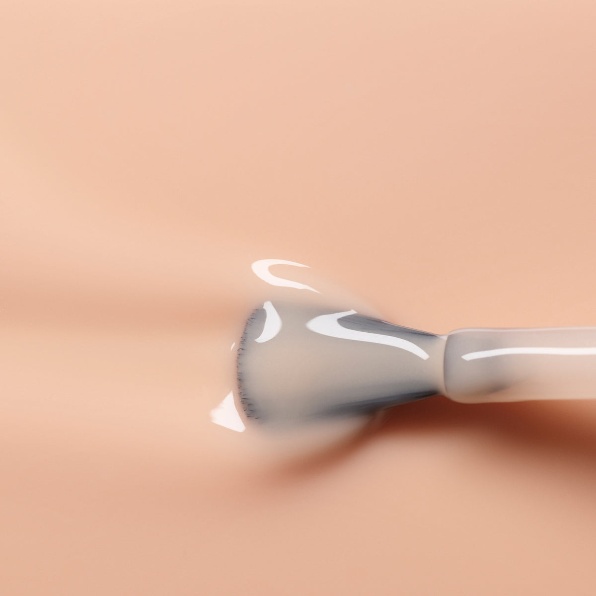 A close-up of a makeup brush spreading Manucurist&